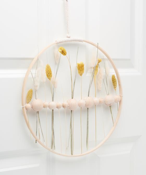 Holzring mit Holzkugeln und Trockenblumen